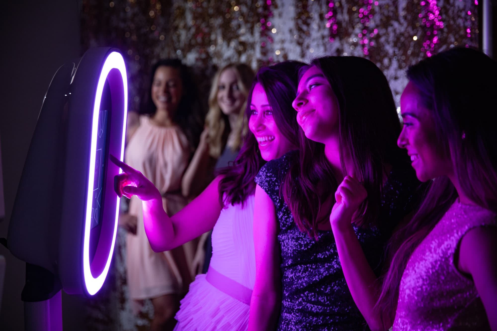 Guests posing at a glowing ring-light booth