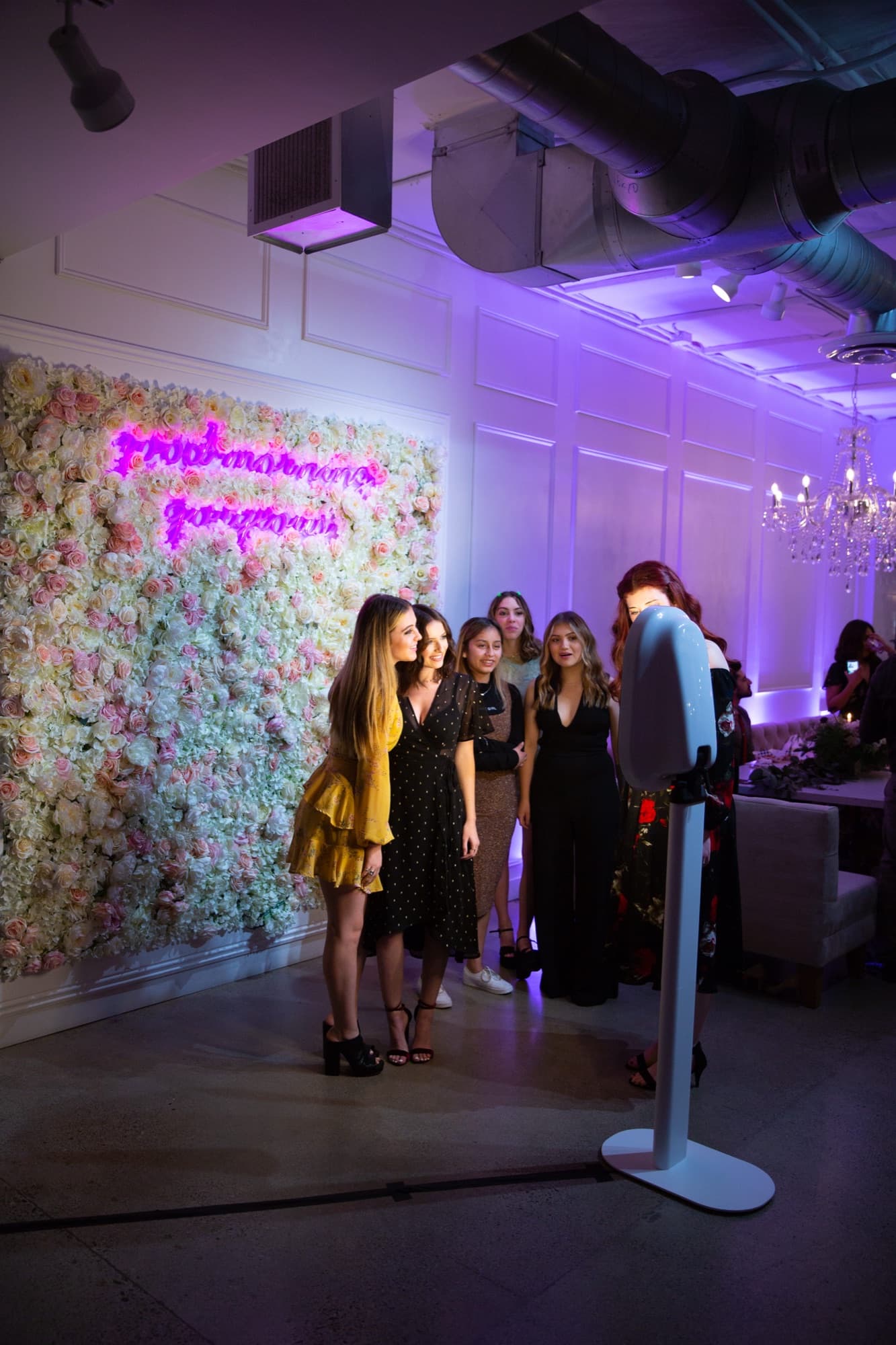 Booth set up in front of a flower wall