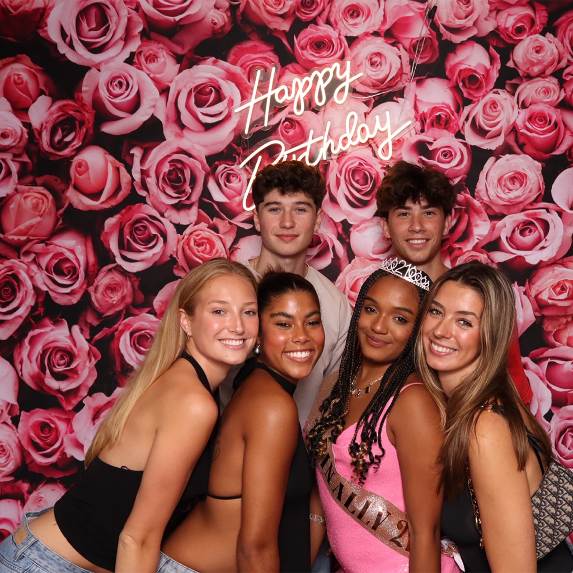 Birthday friends in front of a rose wall