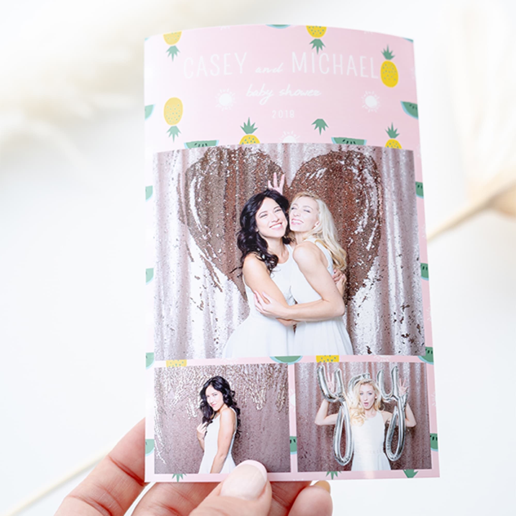 Holding a print in front of a heart backdrop