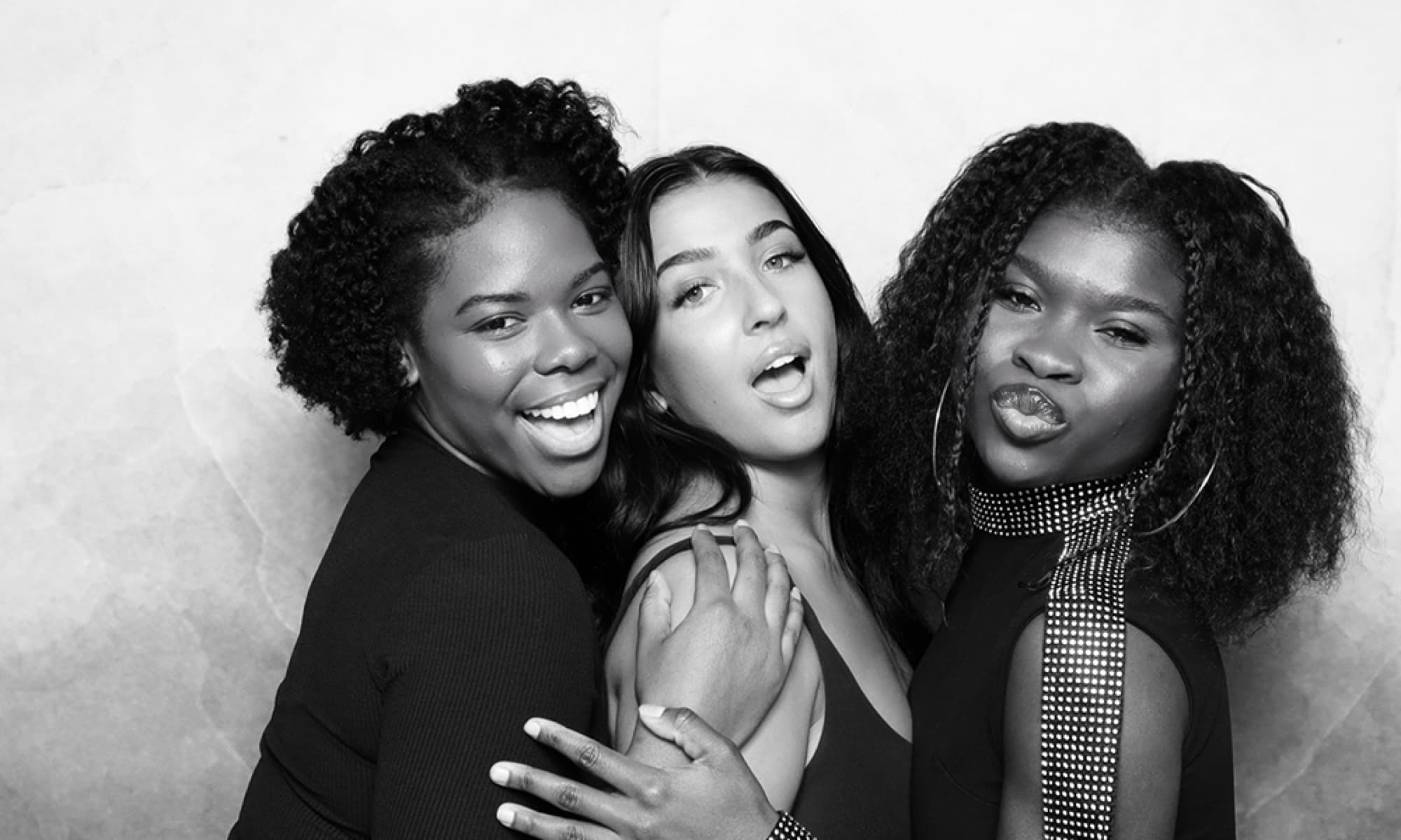 Three friends hugging in black and white