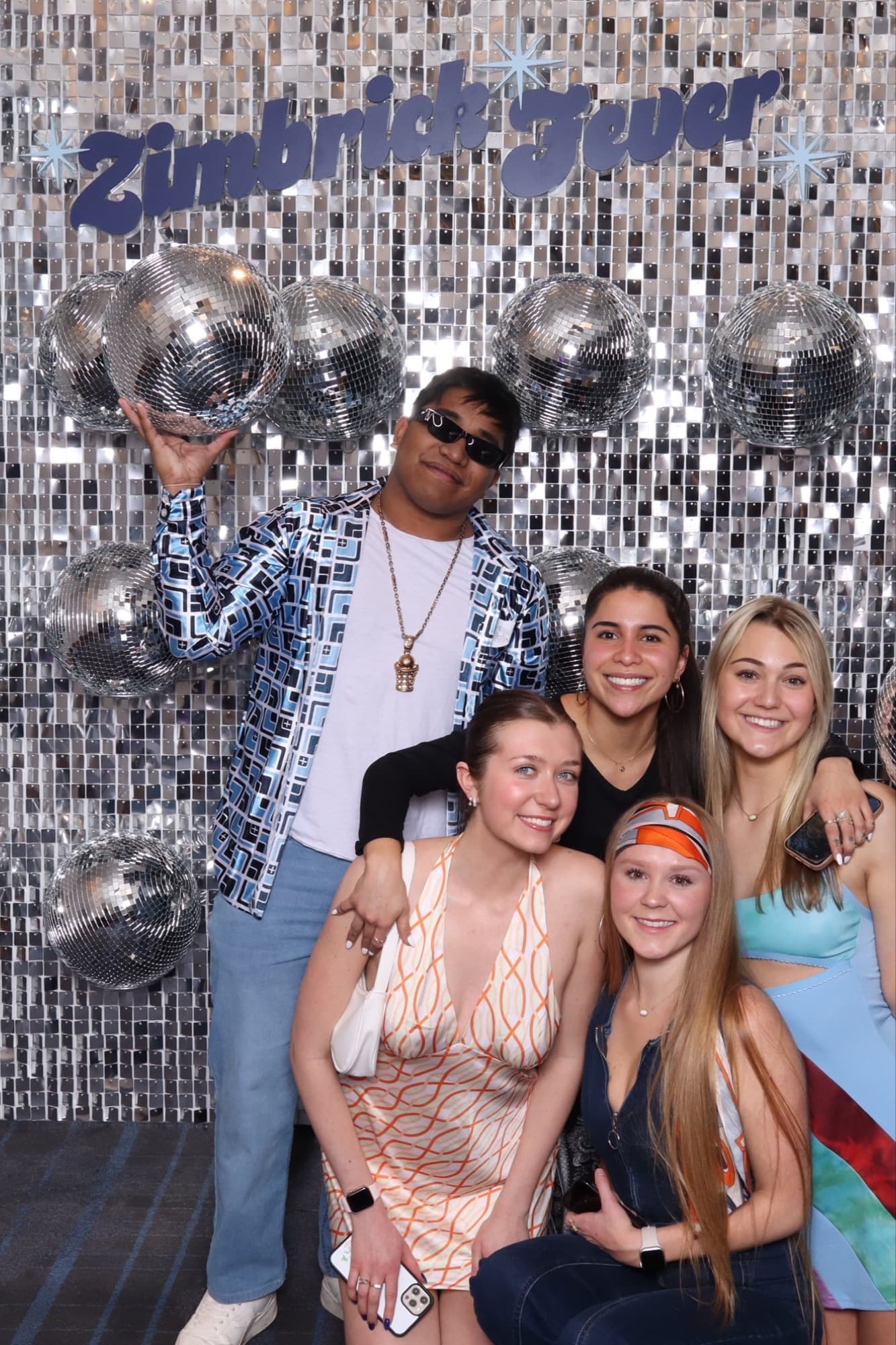 Group in front of a disco ball backdrop
